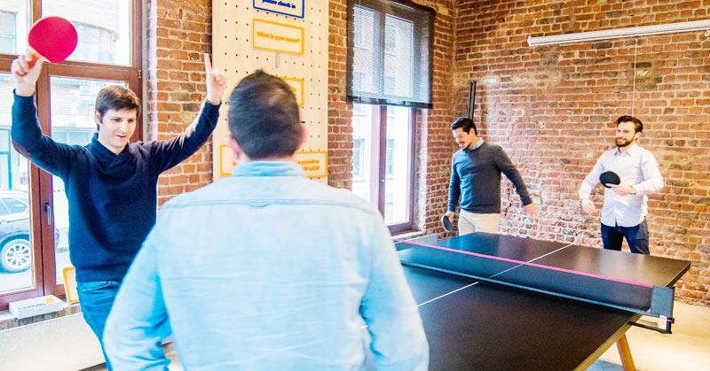 employees playing table tennis together
