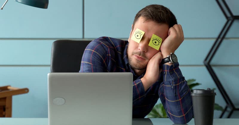 employee sleeping at his computer