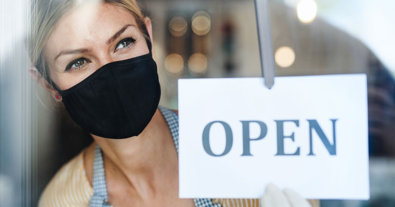 store owner turning sign to OPEN