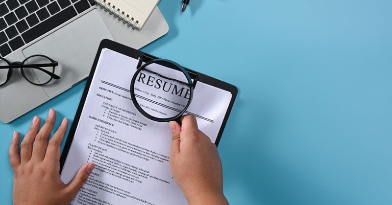 hr looking at resume with magnifying glass